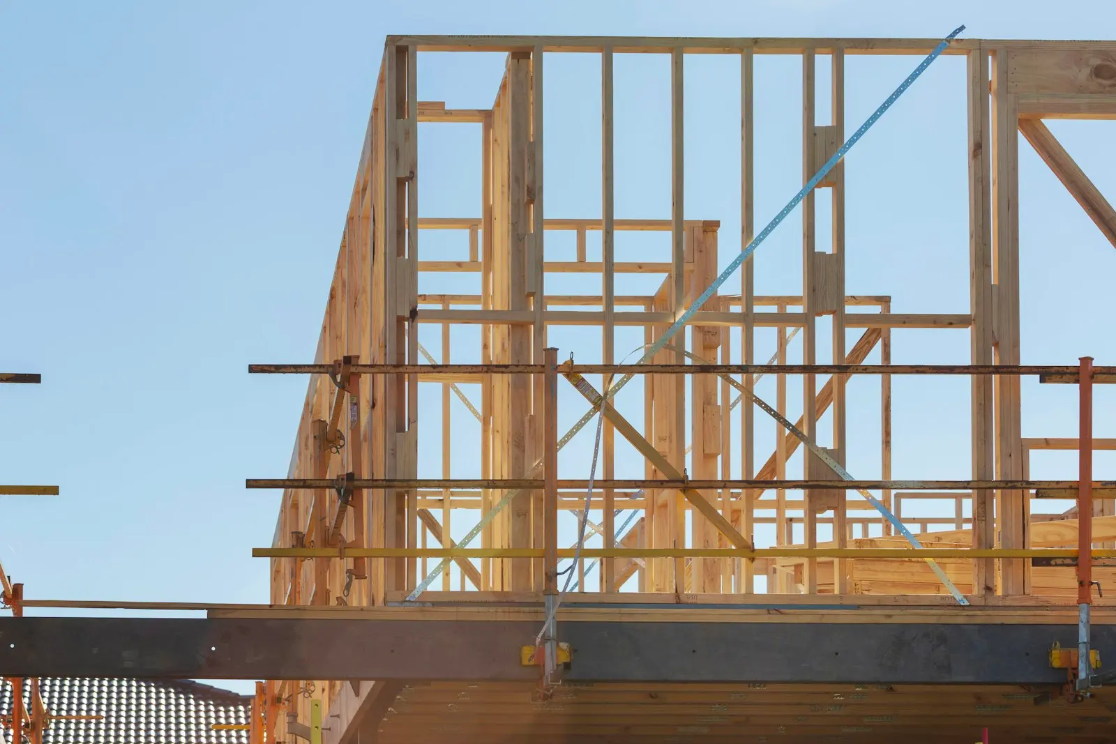 Wooden framing of a building under construction with scaffolding, block foundation in Greenville NC