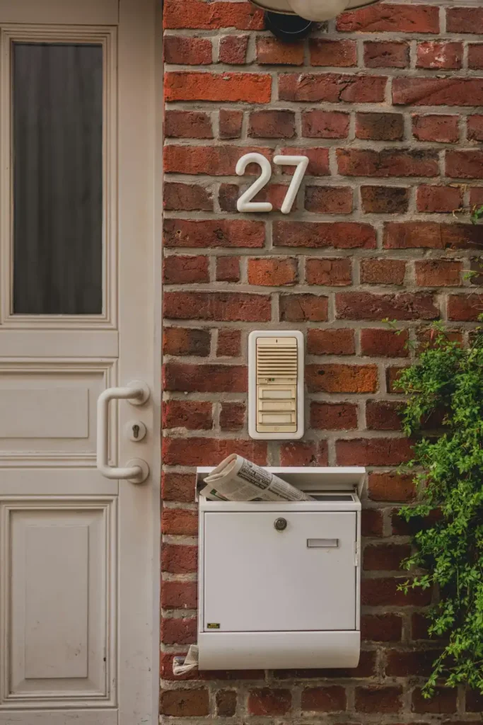 White mailbox with newspaper on brick wall in Chocowinity NC