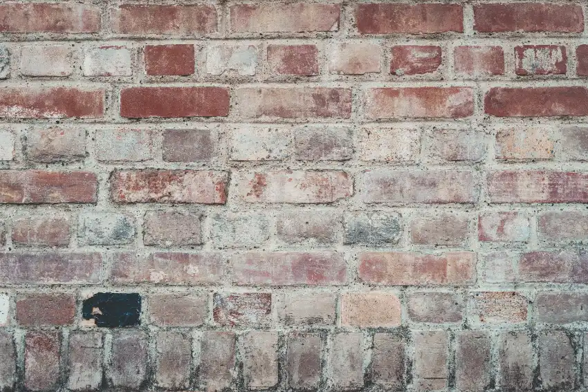 Masonry Repair & Tuckpointing 5 A rustic brick wall with varied red and grey bricks, brick repair, Greenville NC