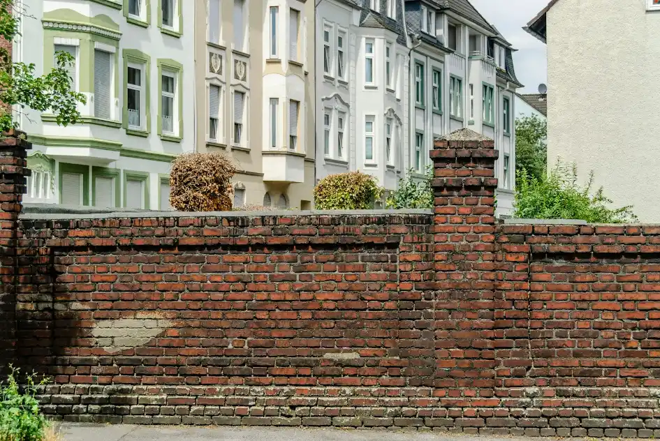 Brick wall along a property line beside town homes