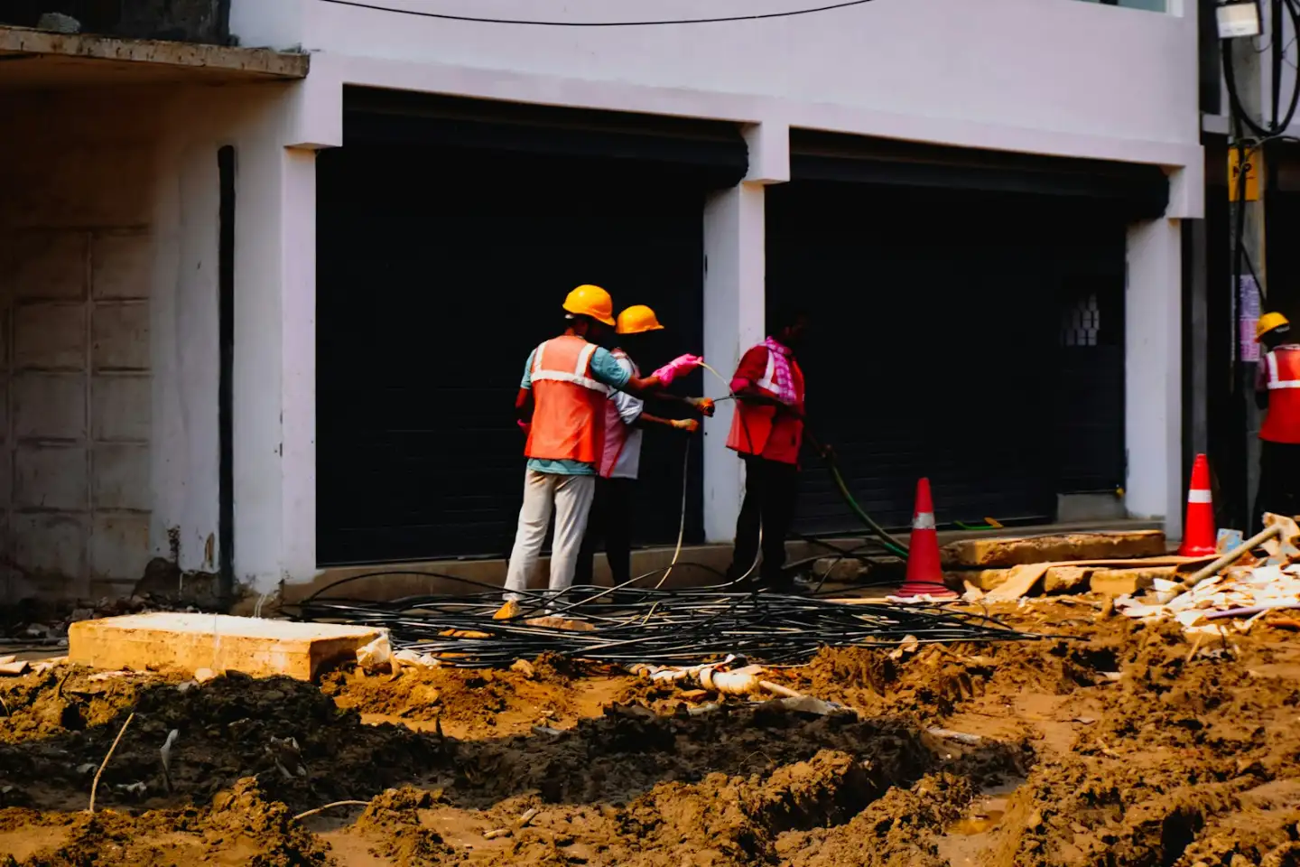 Construction workers in hard hats near a building, concrete cutting in Greenville NC