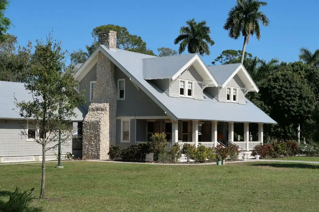 A grey house with a stone chimney and porch in Fort Myers, Florida, masonry and concrete