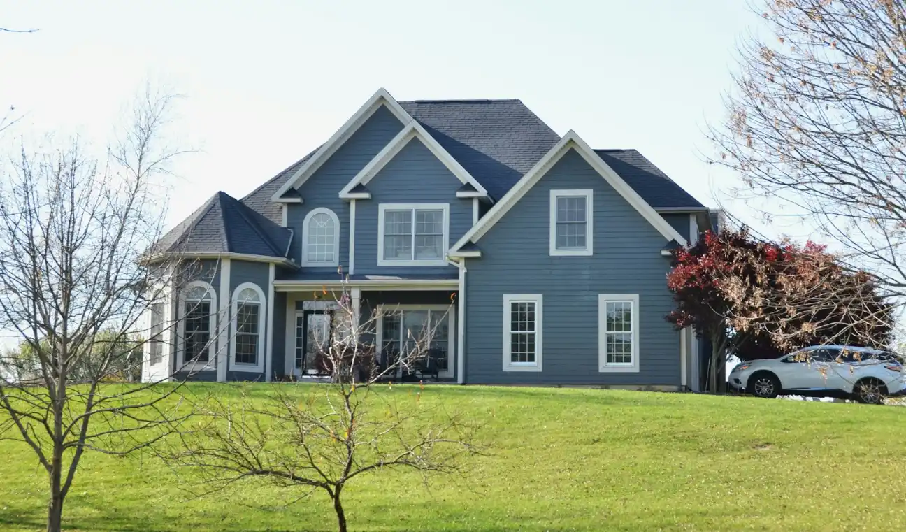A large blue house sits on a grassy hill, masonry and concrete in Bath NC