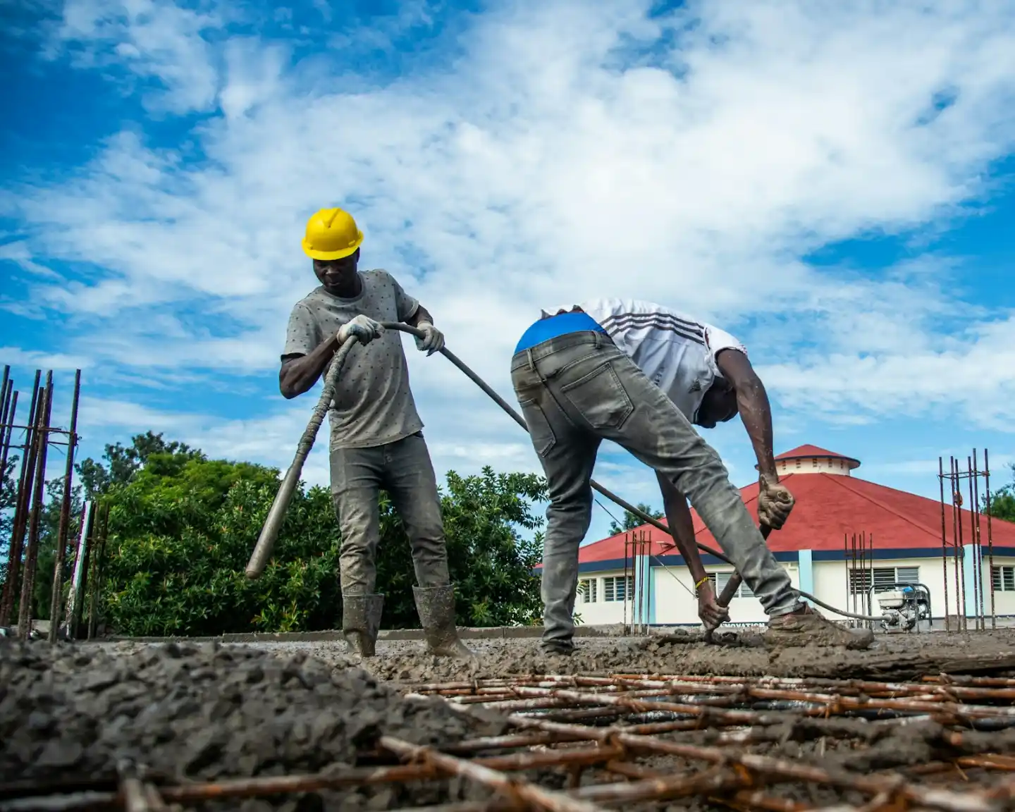 Masonry crew building a wall outside a home on a sunny day