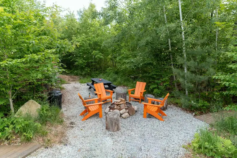 Outdoor fire pit with orange chairs and a picnic table in Greenville NC
