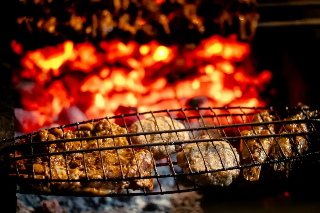 Meat grilling over glowing hot coals, outdoor kitchen in Greenville NC