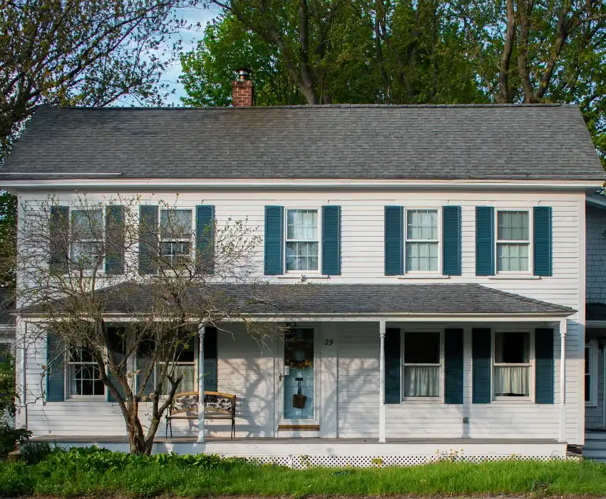 A white house with blue shutters and a porch, porch steps in Greenville NC