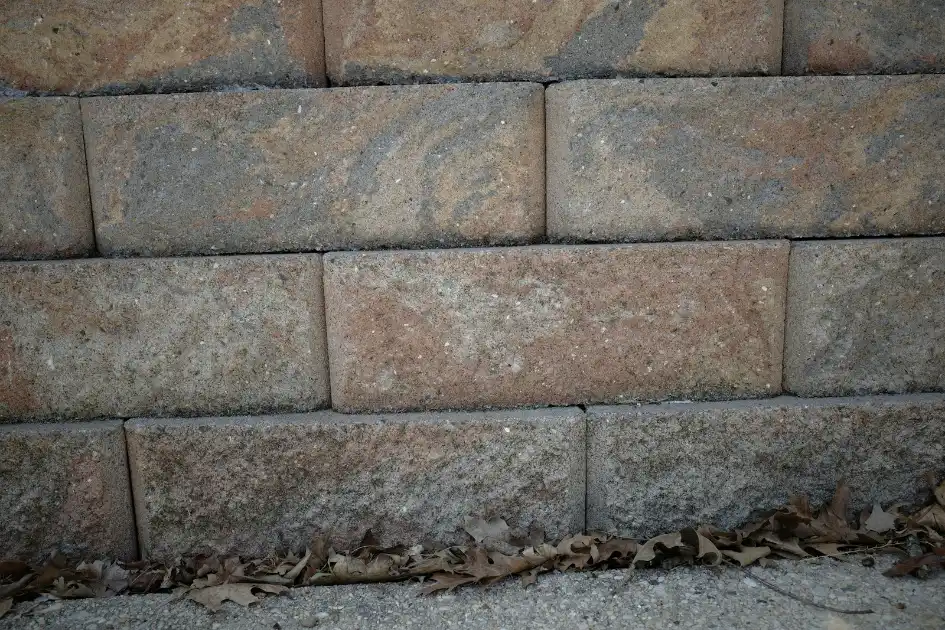 Stacked stone wall with dry leaves at the base, retaining wall in Greenville NC