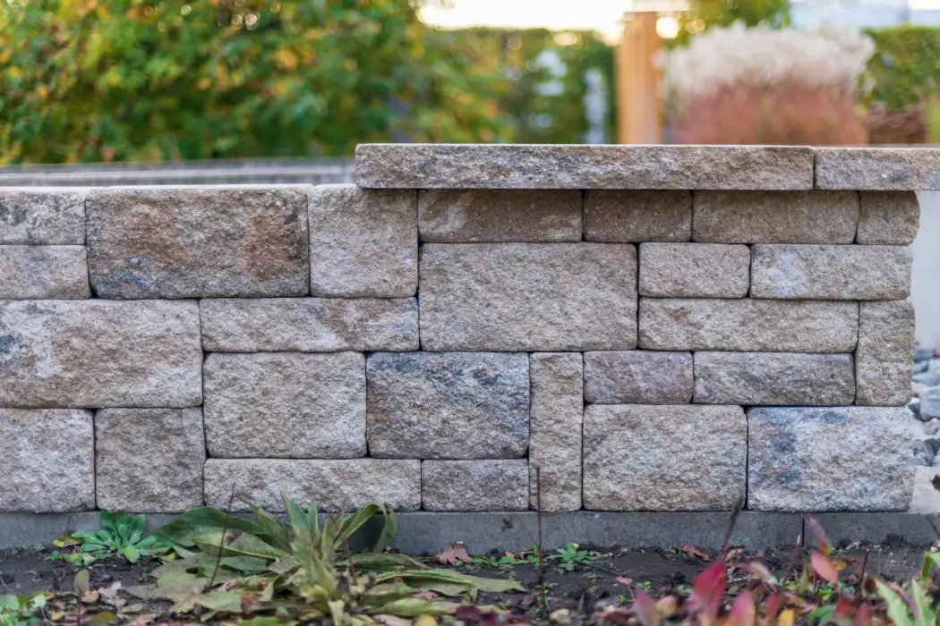 Stone wall with plants in the foreground, retaining wall in Greenville NC