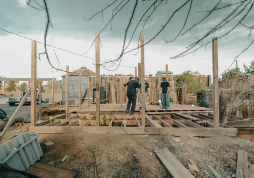 Construction workers building a wooden structure outdoors, block foundation in Greenville NC