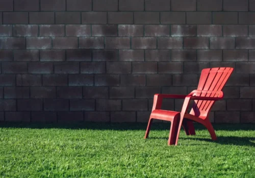 Block privacy wall around a backyard lawn with a patio chair
