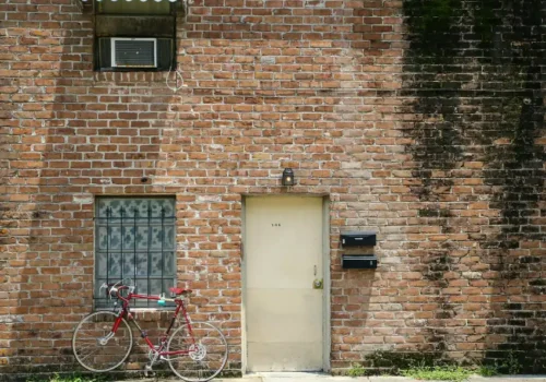 Red bicycle parked beside brown brick wall, brick mailbox in Chocowinity NC