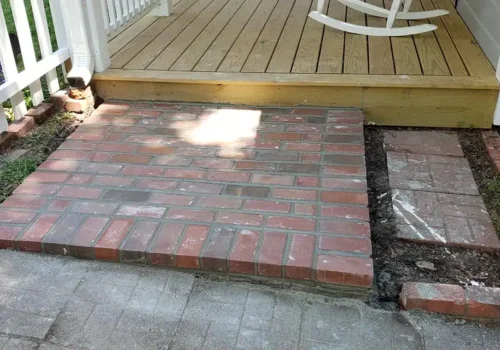 Brick paver patio built next to a front porch