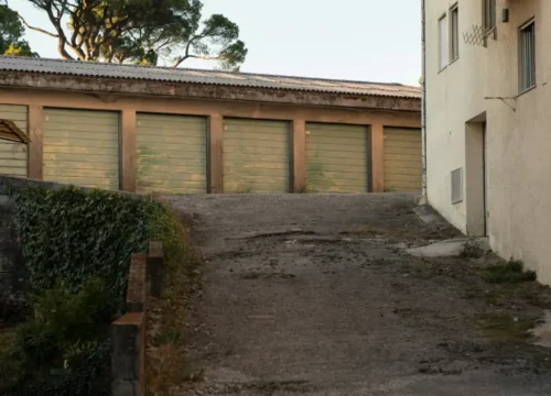 A row of green garage doors at the end of a paved driveway, concrete driveway in Washington NC