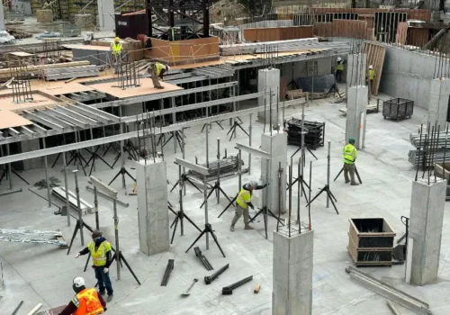 A group of men standing around a building under construction, concrete footing in Greenville NC