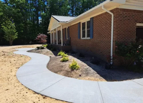 Concrete patio and curved walkway at a brick home