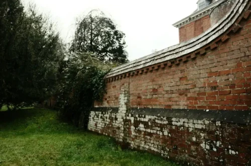 Curved brick garden wall around a backyard lawn in eastern NC