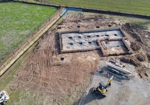 Aerial view of a house foundation laid out on footings in an open field