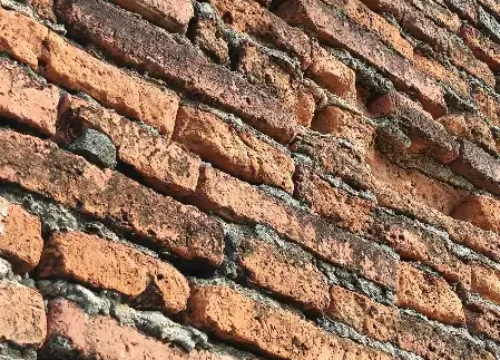 A close up of a brick wall with a clock on it, masonry in Greenville NC