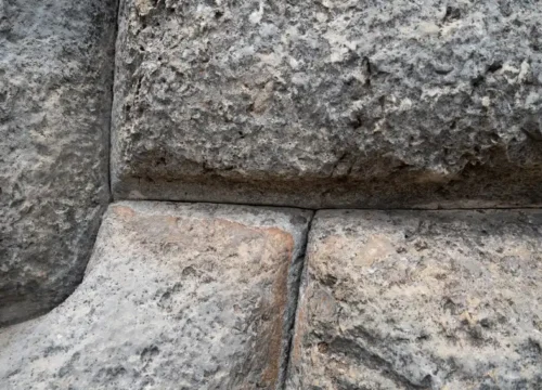 A close up of a rock wall with small cracks, masonry in Greenville NC