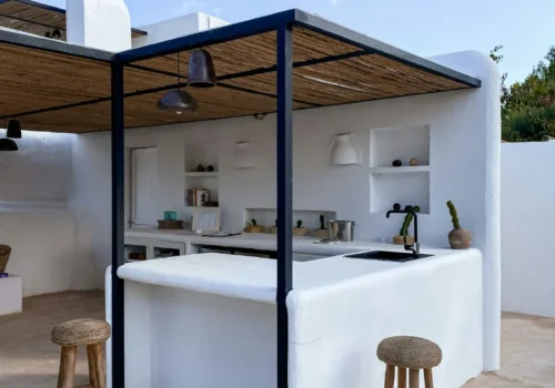 An outdoor kitchen with a bar and stools in Greenville NC