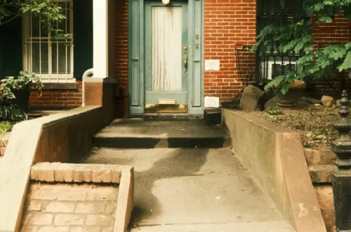 A brick house with a light blue door and stairs, porch steps in Washington NC