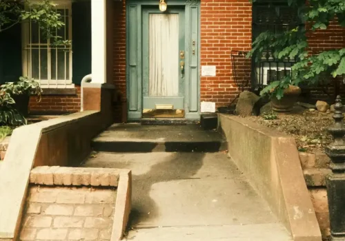 A brick house with a light blue door and stairs, porch steps in Washington NC