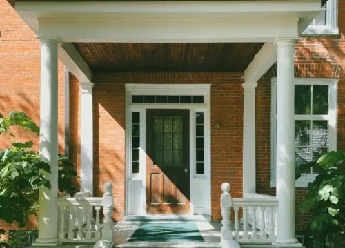 Brown brick house with white wooden door, porch steps in Washington NC