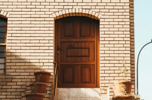 Brown wooden door on brown brick building, porch steps in Bath NC