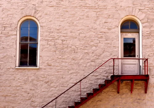 Brown wooden staircase beside brown brick wall, porch steps in Bath NC