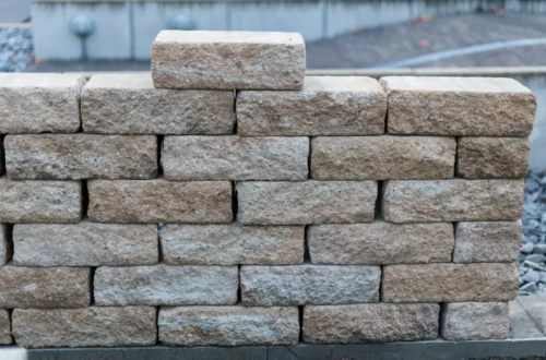 A wall made of rough, tan-colored stones, retaining wall in Greenville NC