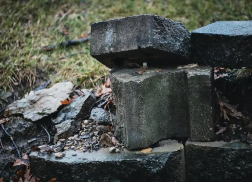 A pile of rocks sitting on top of a grass covered field, retaining wall in Greenville NC