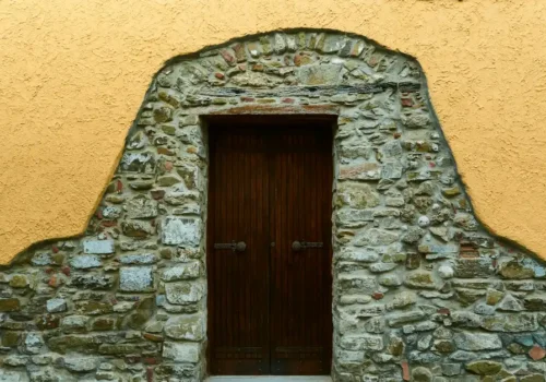 A stone building with a wooden door and window, stone masonry in Greenville NC